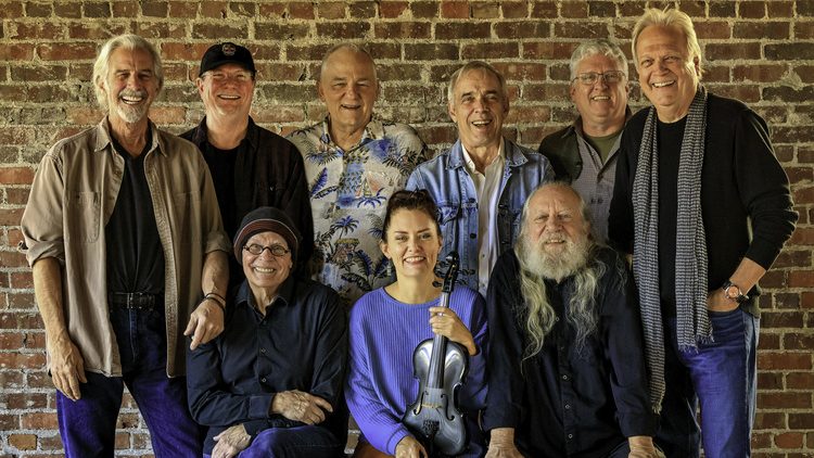 Members of the Ozark Mountain Dare Devils posed in front of a brick wall