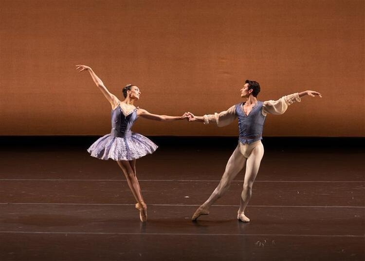 Two dancers in costume peform on stage