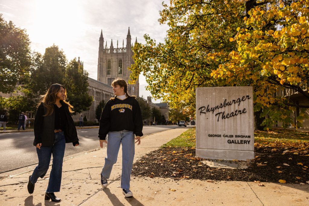 two students walk together outside Rhynsburger Theatre