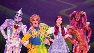 Four costumed performers on stage depict characters from 