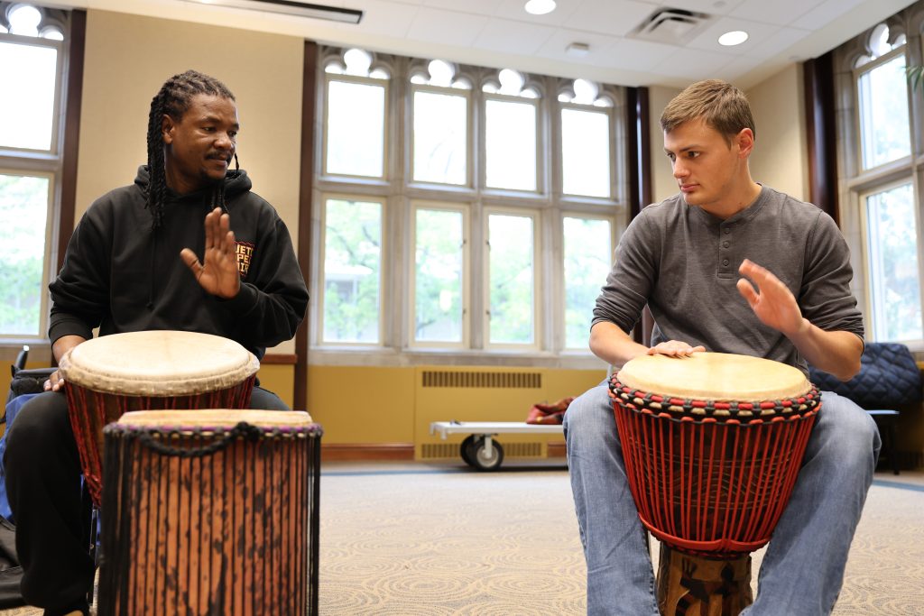 Sipho Ngcamu along with a Mizzou percussion student, drum together.